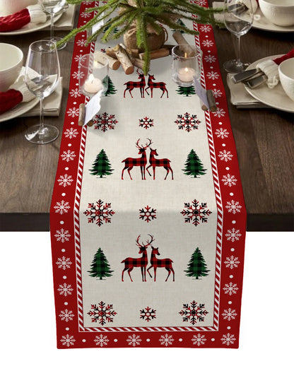 Linen Christmas table runner with tree print on festive dining table.