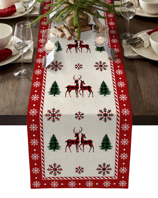 Linen Christmas table runner with tree print on festive dining table.