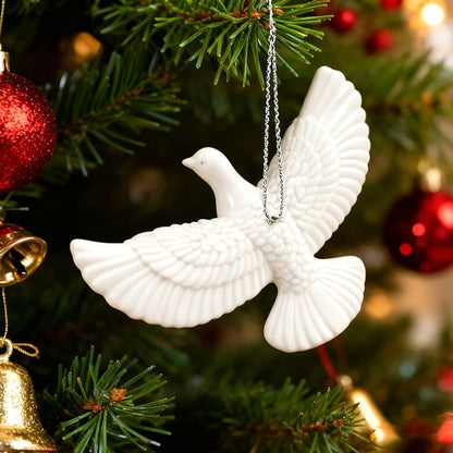 White dove Christmas ornament hanging on decorated tree.