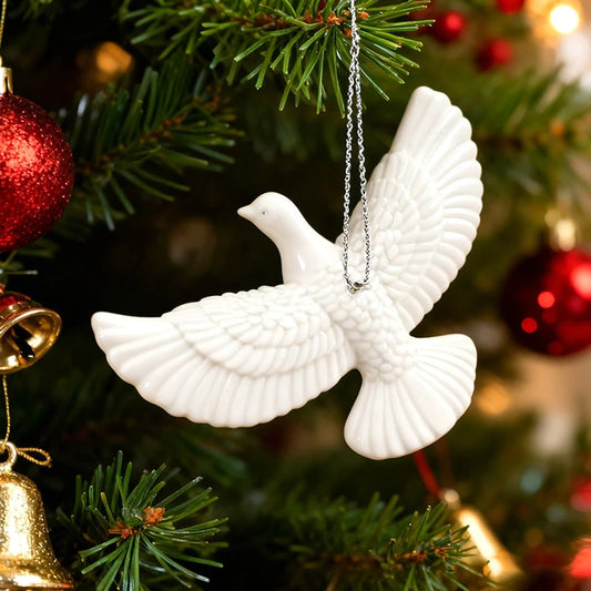 White dove Christmas ornament hanging on decorated tree.