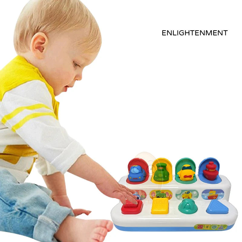 toddler pressing button on pop-up activity toy
